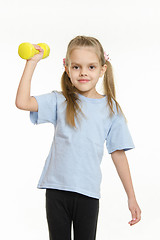 Image showing The girl raised her right arm dumbbell