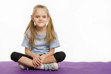 Image showing Six year old girl sitting on the mat for practice