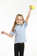 Image showing Six year old girl held up a dumbbell