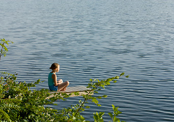 Image showing Little girl meditating by the lake