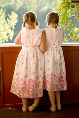 Image showing Twin girls on porch in summer dresses