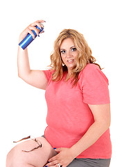 Image showing Plus size woman straying hairspray on.