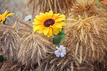 Image showing Decoration of artificial flowers and ears of corn.