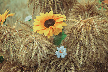 Image showing Decoration of artificial flowers and ears of corn.