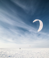 Image showing Kiteboarder with blue kite on the snow