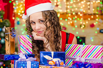 Image showing Beautiful girl at a table with Christmas gifts