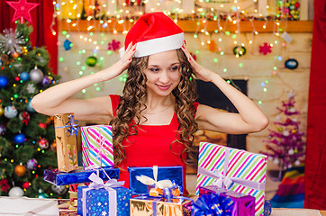 Image showing Beautiful girl clutching her head when choosing a gift