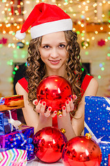 Image showing The girl is holding a big Christmas ball