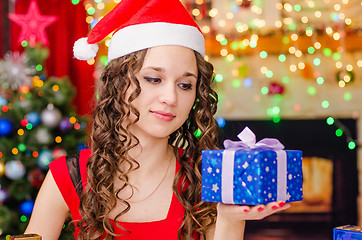 Image showing Beautiful girl looking at Christmas gift