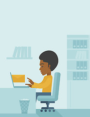 Image showing Young african man sitting infront of a computer laptop.