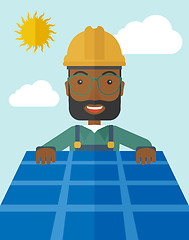 Image showing Man putting a solar panel on the roof.