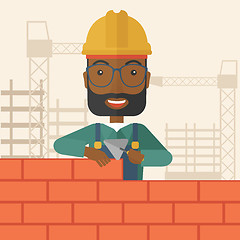 Image showing Black builder man is building a brick wall.