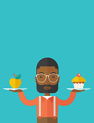 Image showing Man carries with his two hands cupcake and apple.