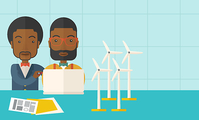 Image showing Two black Workers using laptop with windmills.