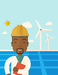 Image showing Black man in solar panel and windmills.