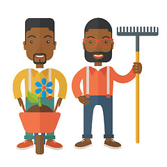 Image showing Two black men with wheelbarrow and rake.