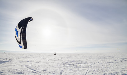 Image showing Kiteboarder with blue kite on the snow