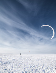 Image showing Kiteboarder with blue kite on the snow