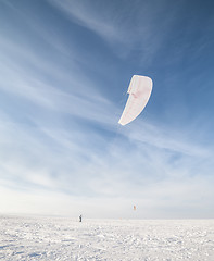 Image showing Kiteboarder with blue kite on the snow