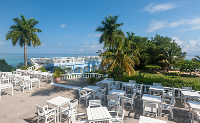 Image showing White tables and chairs  in tropical garden  on a beautiful  beach