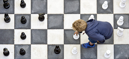 Image showing Child playuing outdoor chess