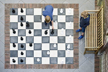 Image showing Two boys playing outdoor chess