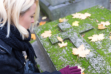 Image showing Solitary woman visiting relatives grave.