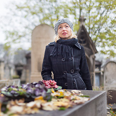 Image showing Solitary woman visiting relatives grave.