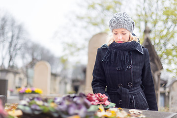 Image showing Solitary woman visiting relatives grave.