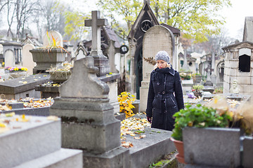 Image showing Solitary woman visiting relatives grave.