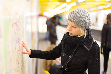 Image showing Lady looking on public transport map panel.