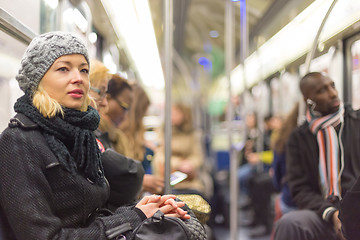 Image showing Woman traveling by subway full of people.