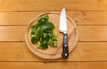 Image showing Green pepper being cut with a knife on a chopping board