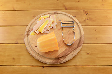 Image showing Butternut squash with a vegetable peeler on a chopping board