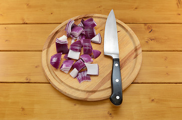 Image showing Chopped red onion with a knife on a chopping board