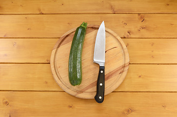 Image showing Green courgette with a knife on a chopping board