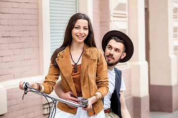 Image showing Young couple standing against the wall and hugging