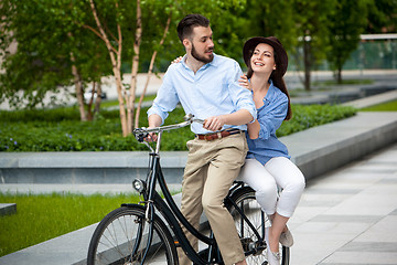 Image showing Young couple sitting on a bicycle 