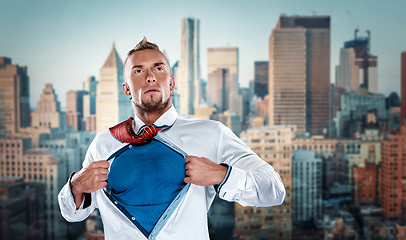 Image showing businessman acting like  super hero and tearing his shirt off