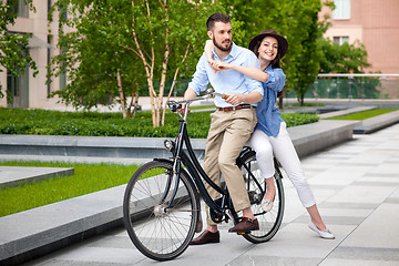 Image showing Young couple sitting on a bicycle 