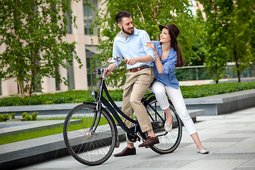 Image showing Young couple sitting on a bicycle 