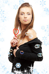 Image showing lovely girl with heart-shaped blower and snowflakes