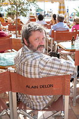 Image showing CCANNES, FRANCE -  SEPTEMBER 17, 2008: Street cafe in Cannes. man sitting on  chair with the inscription Alain Delon