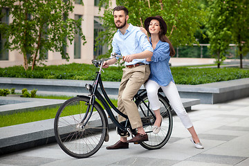 Image showing Young couple sitting on a bicycle 