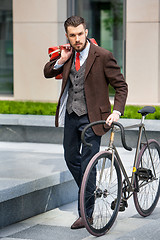 Image showing Handsome businessman and his bicycle