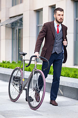 Image showing Handsome businessman and his bicycle