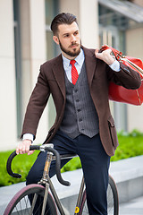 Image showing Handsome businessman and his bicycle