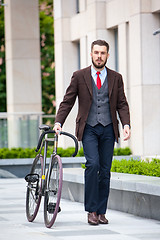 Image showing Handsome businessman and his bicycle