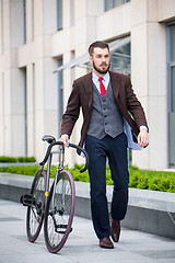 Image showing Handsome businessman and his bicycle