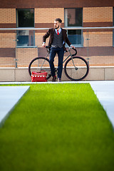 Image showing Handsome businessman and his bicycle